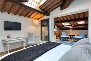 a bedroom with a bed and a desk and a television at Villa Le Calvane in Montespertoli