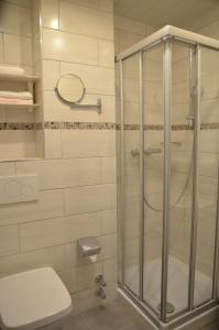 ein Bad mit einer Glasdusche und einem WC in der Unterkunft Hotel Waldersee in Hannover