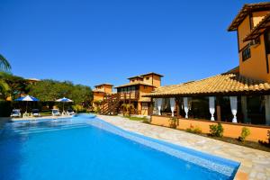 a large swimming pool in front of a building at Pousada Da Ferradura in Búzios