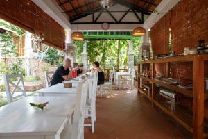 a group of people sitting at tables in a restaurant at Miana Resort Phu Quoc in Phú Quốc