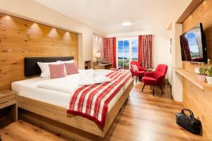 una stanza d'albergo con un letto e una sedia rossa di Hotel Johanneshof a Oberstaufen Altre 27 foto