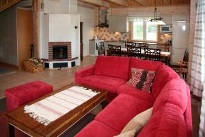 a living room with a red couch and a fireplace at Lomakivi in Kausala