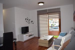 sala de estar con sofá y TV en Apartamento San Isidro, en La Orotava