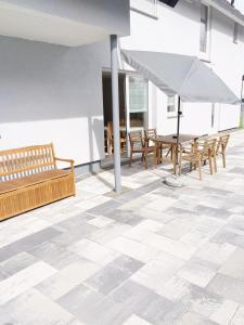 a room with a tile floor with benches and an umbrella at Pension Eichel in Rust