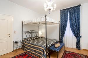 una camera con letto a baldacchino e lampadario pendente di Villa Casanova a Lido di Venezia