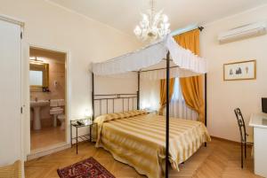 a bedroom with a canopy bed and a bathroom at Villa Casanova in Venice-Lido