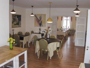 a dining room with tables and chairs and lights at Hotel Frøslev Kro in Padborg