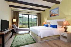a bedroom with a large bed and a television at Le Monte Khao Yai in Mu Si