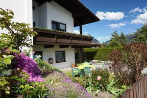 une maison avec un jardin orné de fleurs violettes dans l'établissement Haus Walser, à Tarrenz