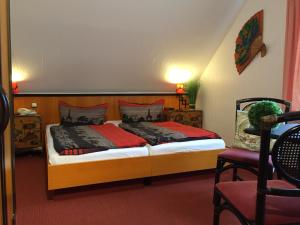 1 dormitorio con 1 cama y 1 silla en Pension Cora, en Boltenhagen