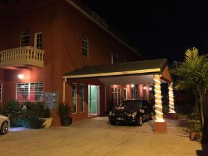 a car parked in front of a house at night at Montecristo Inn in Piarco