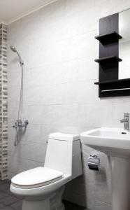 a white bathroom with a toilet and a sink at Saipan Family Residence in Chalan Kanoa