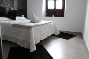 a bedroom with a bed with a white blanket and a window at Nest Flats Granada in Granada