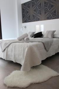 Nest Flats Granada في غرناطة: امرأة مستلقية على سرير في غرفة النوم