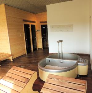 uma grande casa de banho com banheira no meio de um quarto em EA Horský Hotel Hájenka em Modrava