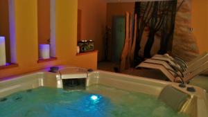 a jacuzzi tub in a room with some chairs at Agritur Leita in Tuenno