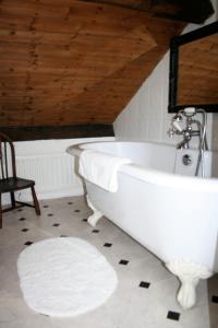 a white bath tub in a bathroom with a wooden ceiling at Teesdale Rooms in Whitby