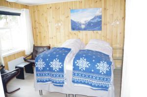 a bedroom with two beds with blue and white blankets at Lunheim in Geiranger in Geiranger
