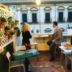 a man and a woman sitting at a table in a restaurant at Jardin De France in Palermo