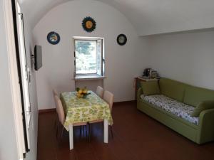 a living room with a table and a couch at Casa Vacanze Bouganvillea in Cetara