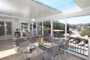 d'une salle à manger avec des tables et des chaises sur un balcon. dans l'établissement Villa Tricoli B&B avec Piscine, aux Issambres