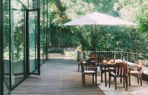 un patio con tavoli, sedie e ombrellone di Fuente Aceña Hotel Boutique a Quintanilla de Onésimo