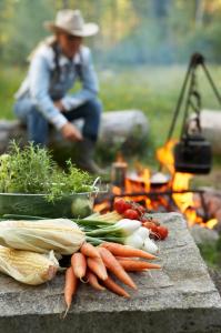 a bunch of vegetables on a table next to a fire at J A Ranch Bed & Breakfast in Strömsnäsbruk