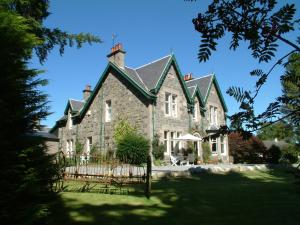 a large stone house with a green roof at Greystones B&B in Kingussie