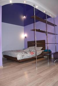 een slaapkamer met een bed met een paarse muur bij LUX на Литейной 17-А in Dnipro