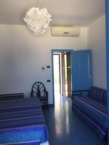 a bedroom with two beds and a chandelier at La Sirenetta Park Hotel in Stromboli