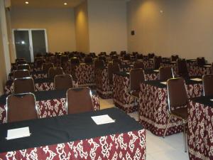 una habitación con hileras de mesas y sillas en Hotel Koening, en Cirebon