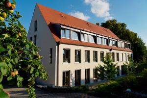 een groot wit gebouw met een oranje dak bij Gasthof Schiller bei Bamberg in Strullendorf