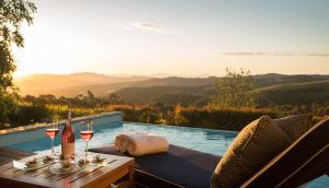 einen Tisch mit Weingläsern und eine Flasche Wein in der Unterkunft Delaire Graff Lodges and Spa in Stellenbosch