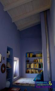 a blue room with a bed and books at Verdemare e Verdementa in Portovenere