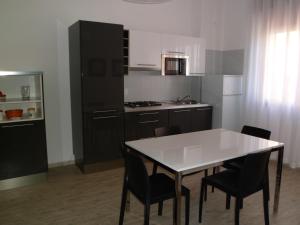 a kitchen with a white table and black cabinets at Residence Eur in Sottomarina
