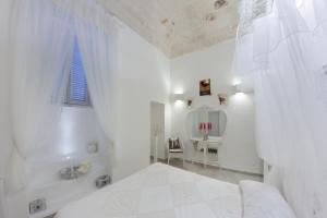Baño blanco con bañera y lavamanos en Maruska Residenze, en Fasano