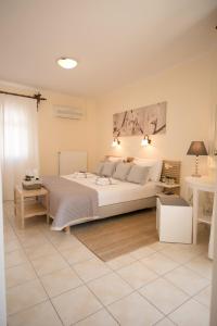 a bedroom with a large white bed and a table at Marina's House in Parga