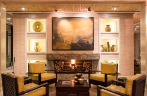 a living room with a fireplace and a painting on the wall at Delaire Graff Lodges and Spa in Stellenbosch