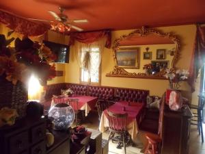 une salle à manger avec des tables roses et un miroir dans l'établissement Home Story, à Ozzano dell'Emilia