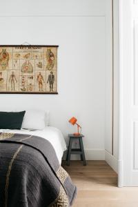 a bedroom with a bed and a poster on the wall at The Lisboans Apartments in Lisbon