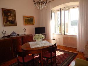 ein Wohnzimmer mit einem Tisch, Stühlen und einem Fenster in der Unterkunft Apartment Dalija in Dubrovnik