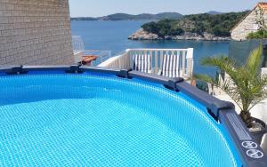 a blue swimming pool with a view of the water at Apartment Ela in Dubrovnik