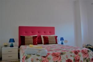 納扎雷的住宿－Ricardo Holidays At Nazaré，一间卧室配有一张大床和红色床头板