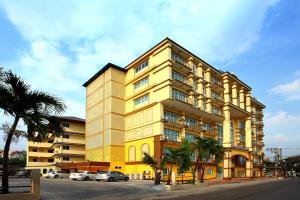 ein gelbes Gebäude mit davor geparkt in der Unterkunft Victoria Nimman Hotel in Chiang Mai