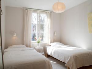 two beds in a room with a window at Kuressaare Turu Apartment in Kuressaare