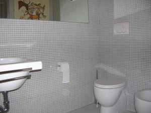 bagno con servizi igienici, lavandino e specchio di b&b undici a Cervia
