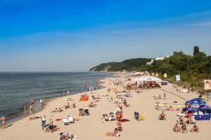 a crowd of people on a beach with the ocean at Dziwnów Wczasowisko in Dziwnów