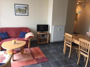 a living room with a couch and a table and a tv at Miramare Wohnung 24 in Kühlungsborn