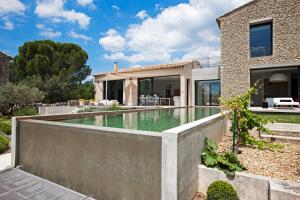 une maison avec une piscine en face d'une maison dans l'établissement BB 12 LUBERON chambres d'hôtes contemporaines, à Gordes