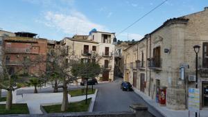 une rue urbaine avec des bâtiments et une voiture sur la route dans l'établissement Casa Natia, à Favara